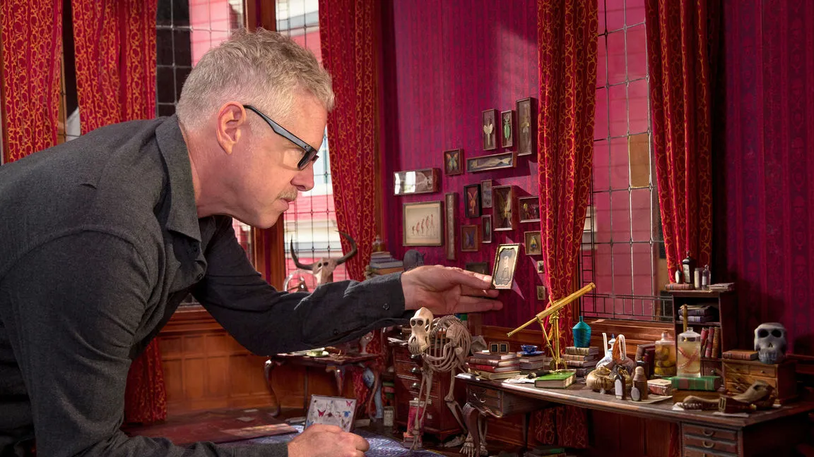 A LAIKA employee adjusting set decorations from Missing Link