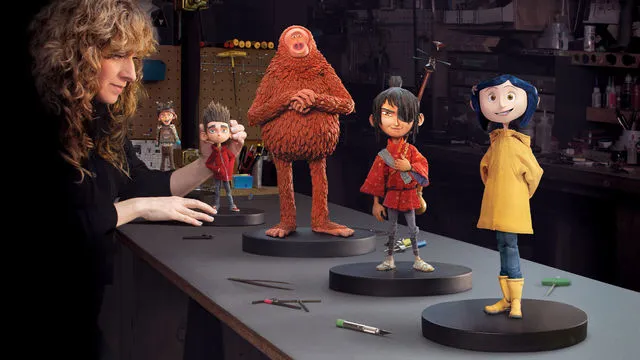 A woman positioning a set of puppets