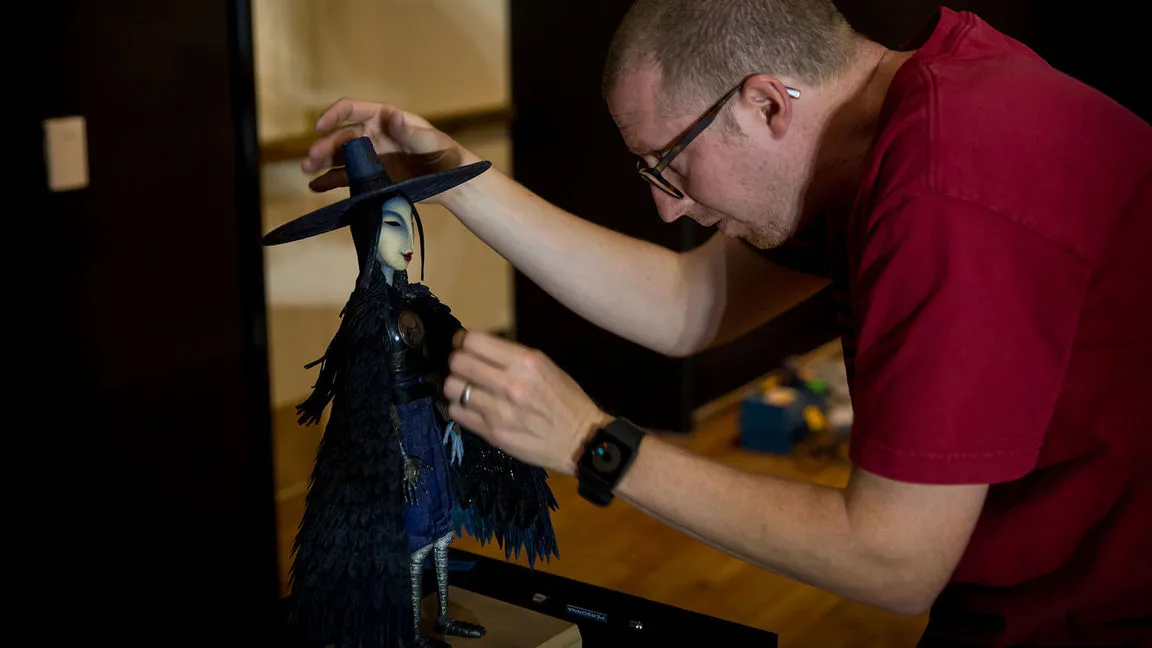 A man adjusting a puppet from Kubo and the Two Strings