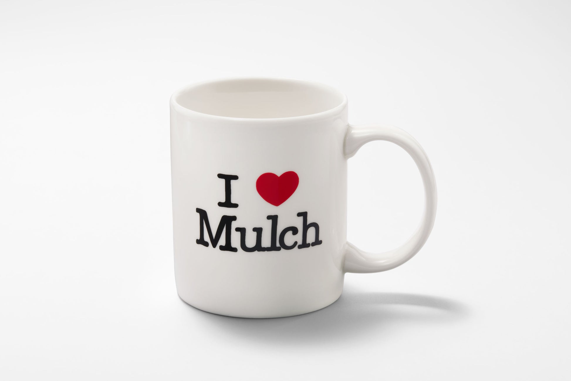 Full view of the ceramic mug that reads “I Heart Mulch”