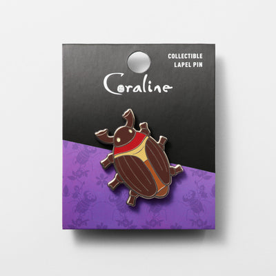 Cocoa Beetle collectible enamel pin displayed with black and purple backer card